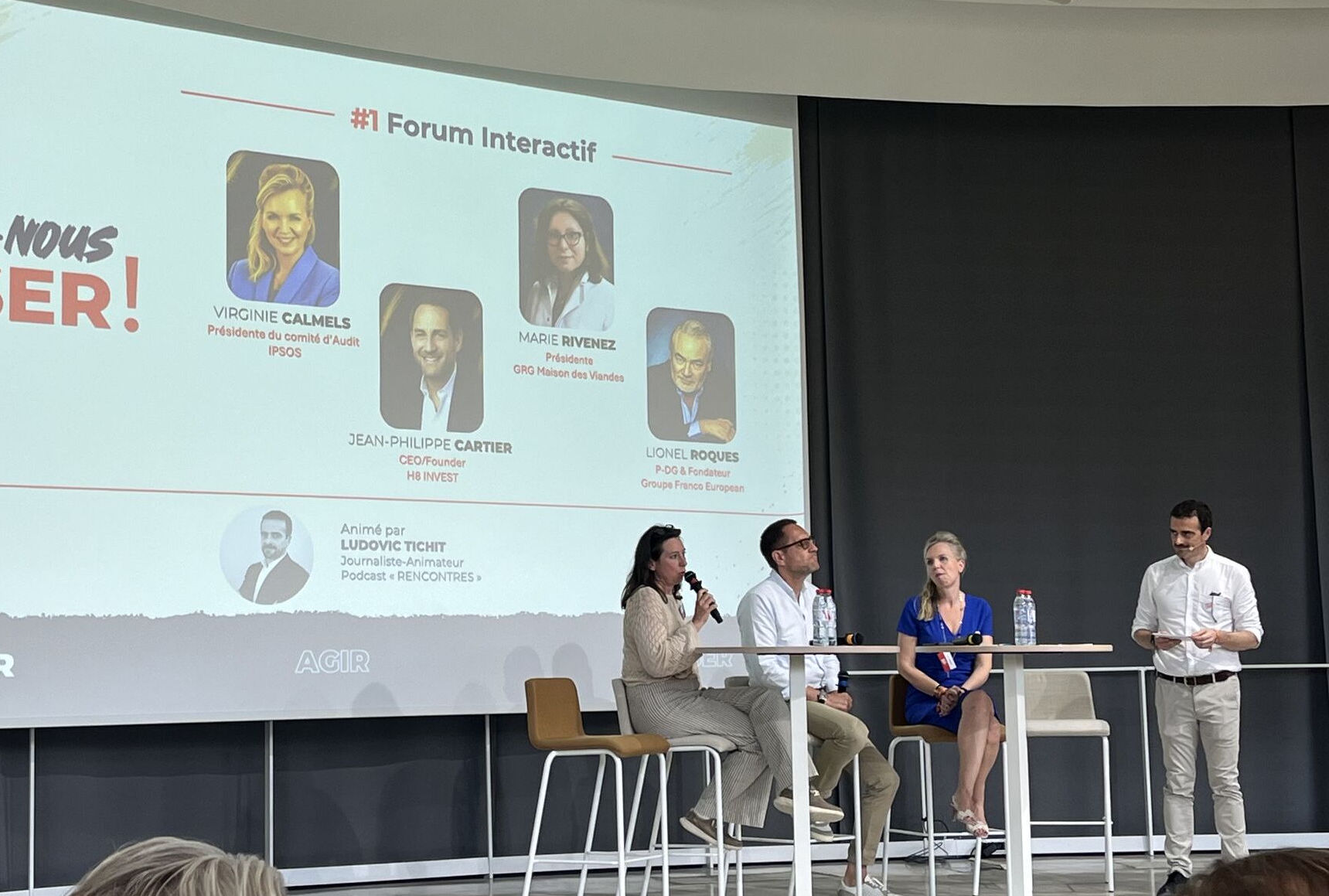 Table ronde animée par un journaliste lors d’un événement d’entreprise.